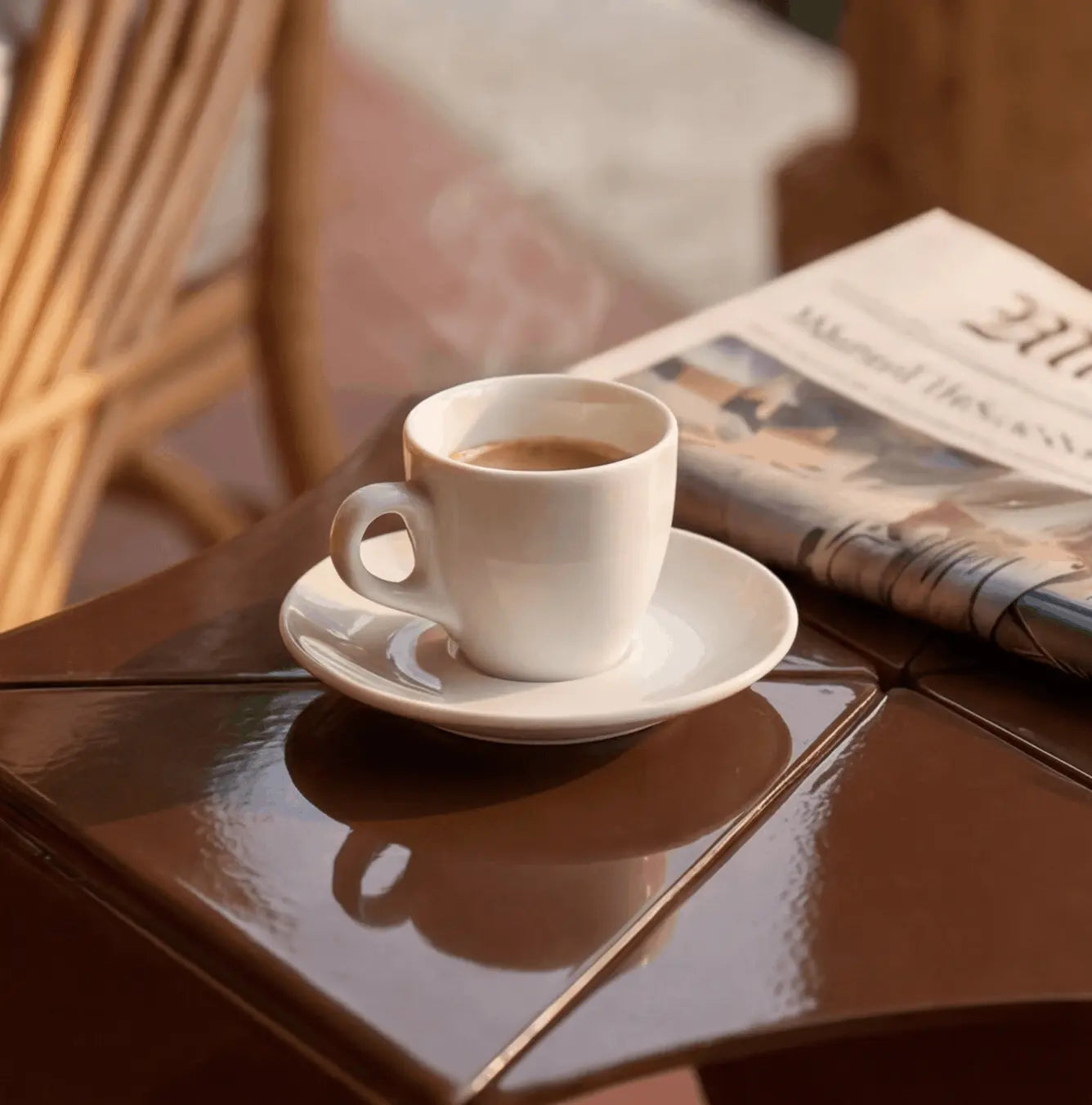 Glossy mahogany surface of the Ferrani Mono Fold side table with an espresso cup, close-up